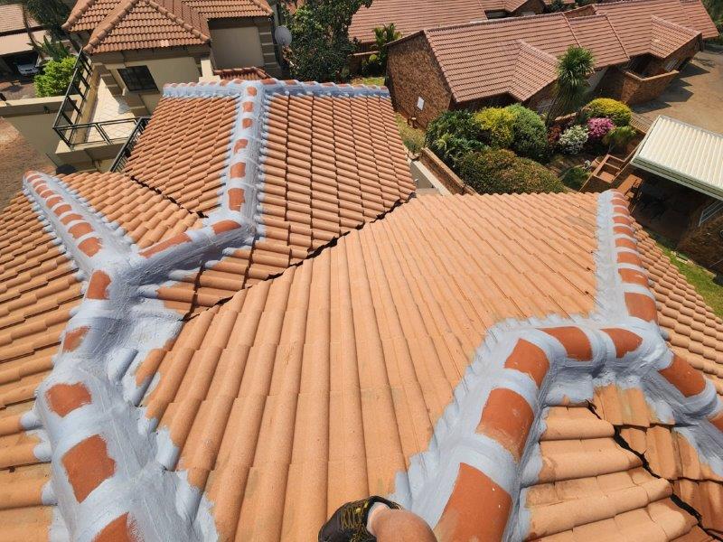 Acrylic waterproofing applied to ridge caps on a tiled roof