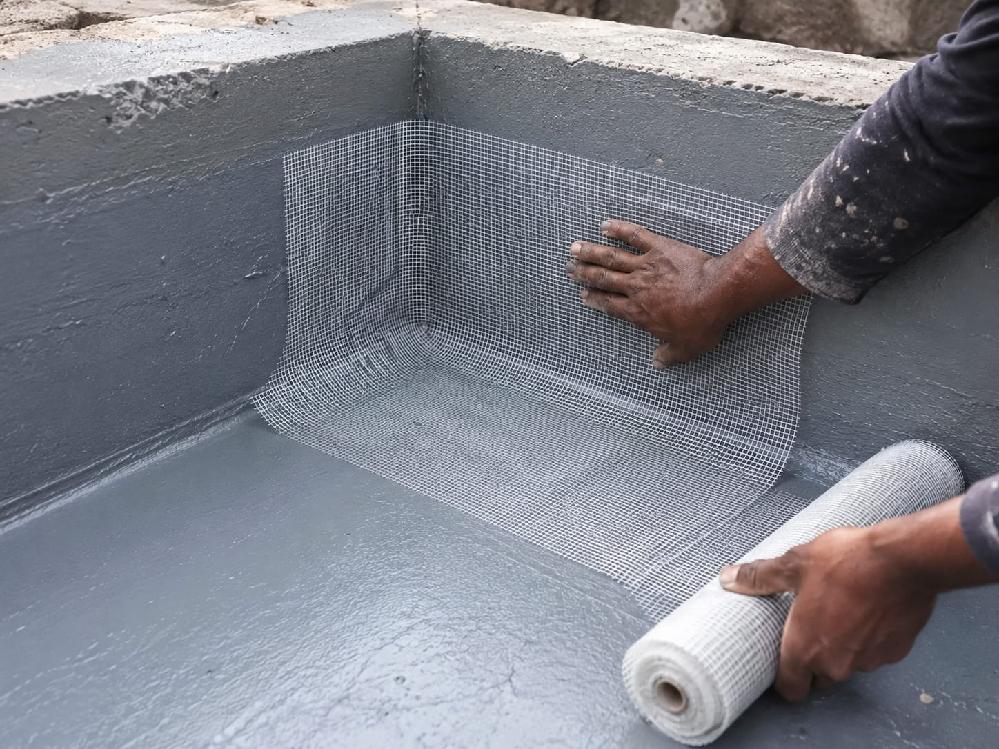 Fibre seal mesh being applied into a waterproofing corner